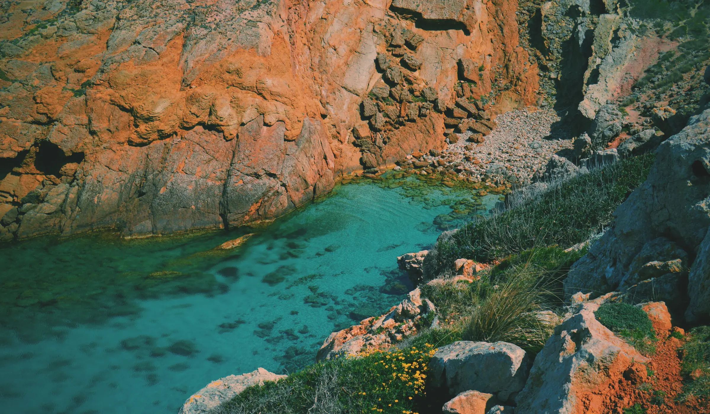 Crique aux roches ocre et à l’eau turquoise